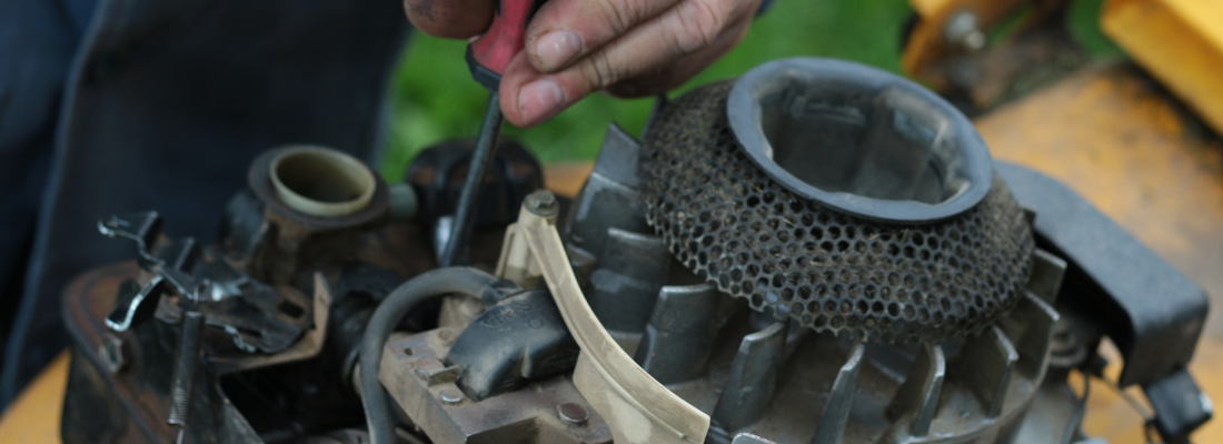 Mechanic repairing engine on lawnmower