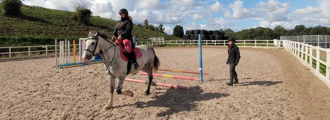 insrtuctor with horse rider under tuition in sand school