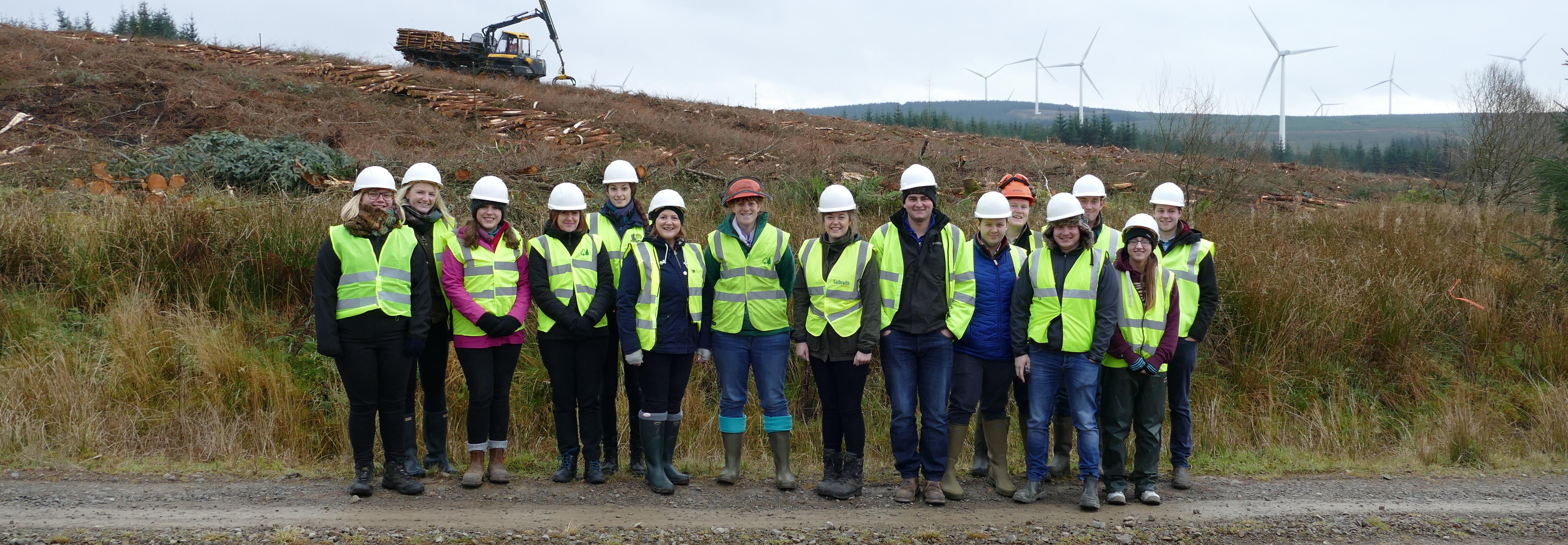 Industry champions in front of harvester