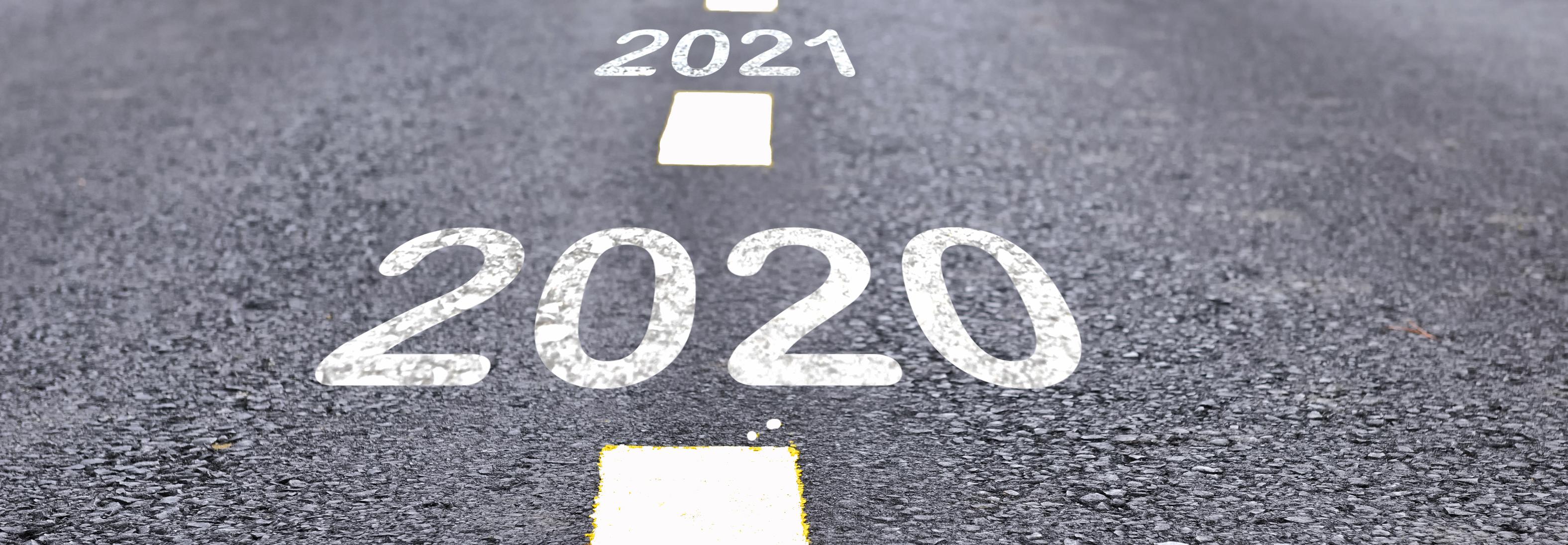 Road with 2020 and 2021 painted white on it into distance