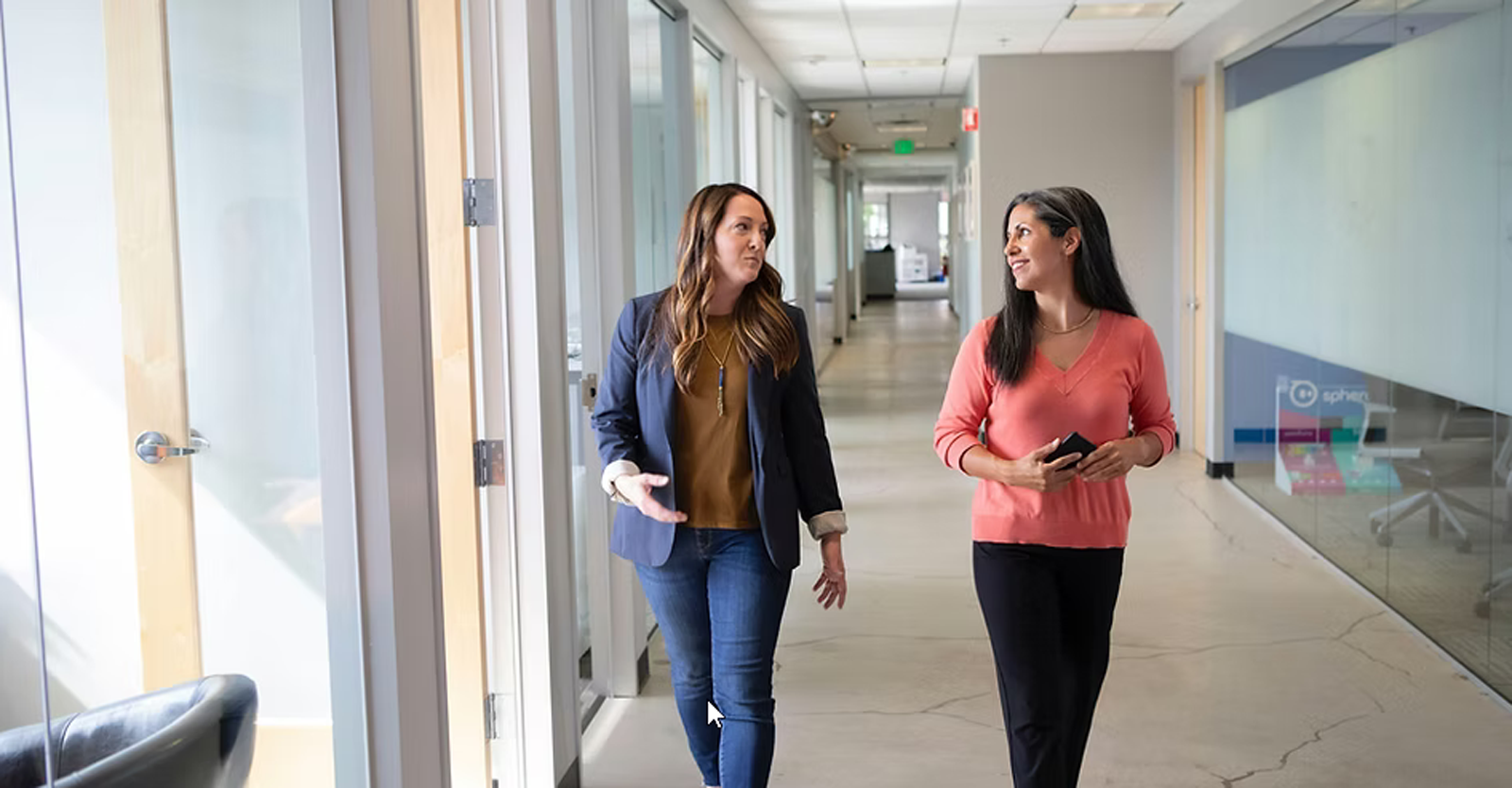 Two women walking down a corridor