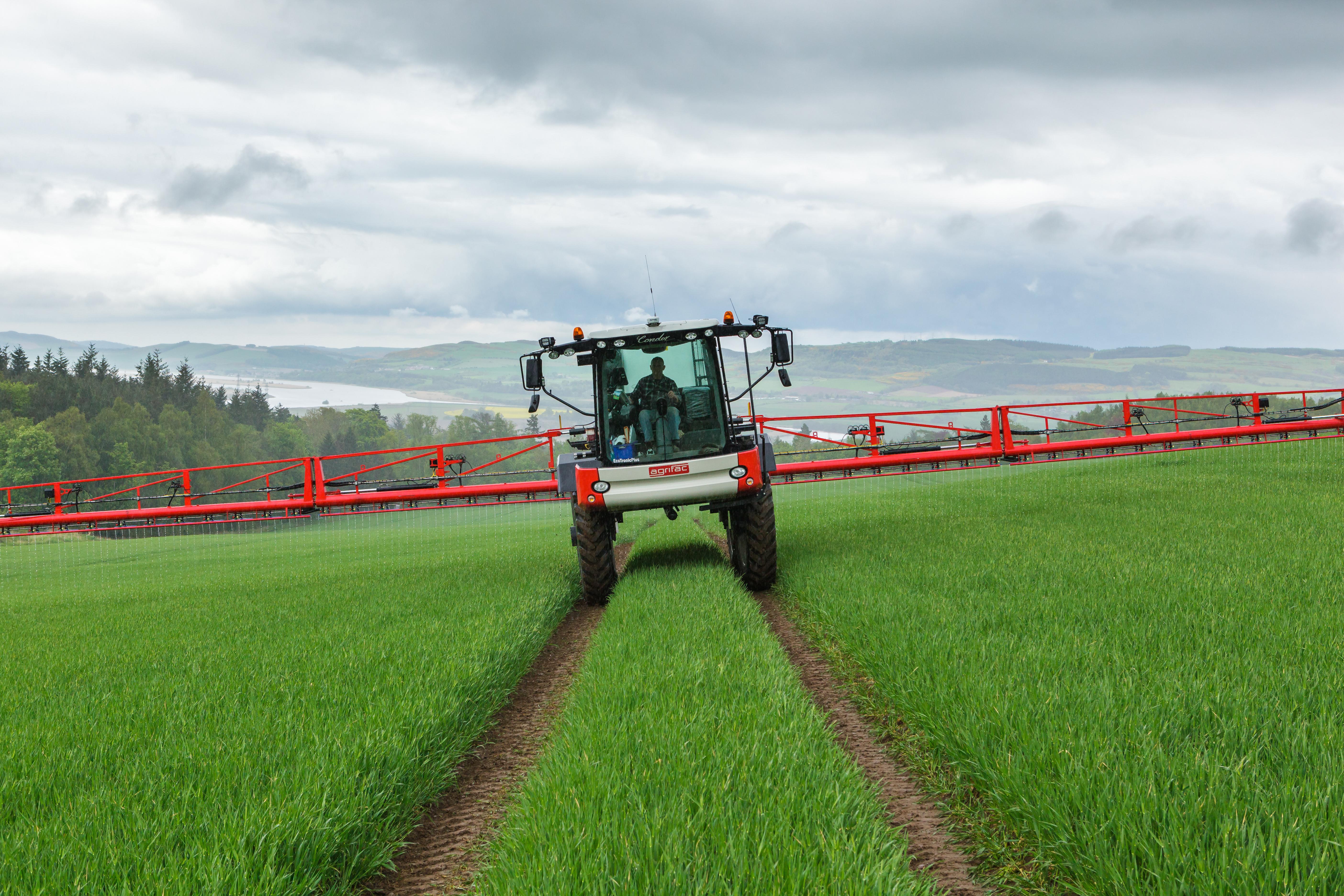 Tractor spraying crops in field