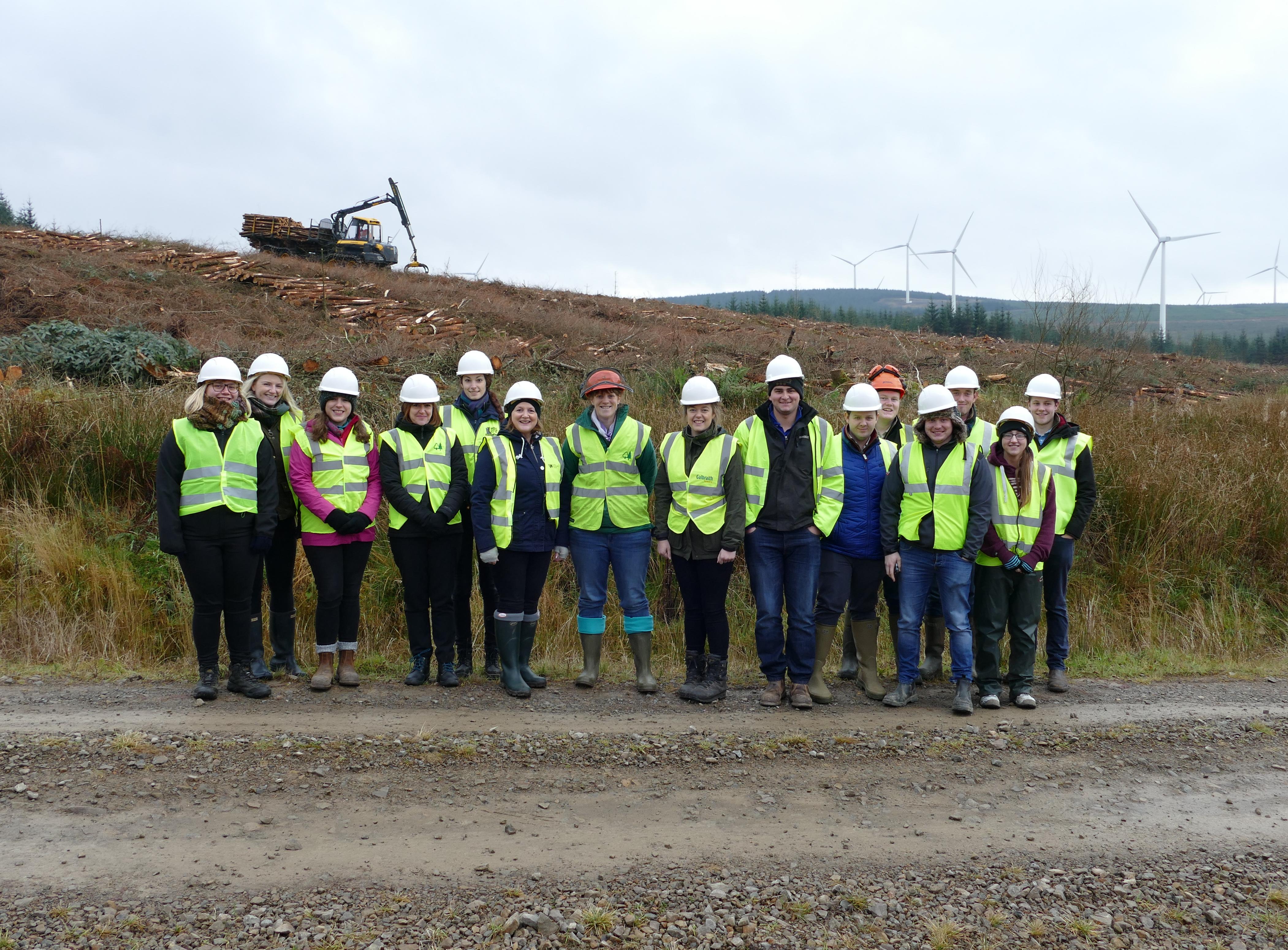 Industry champions in front of harvester