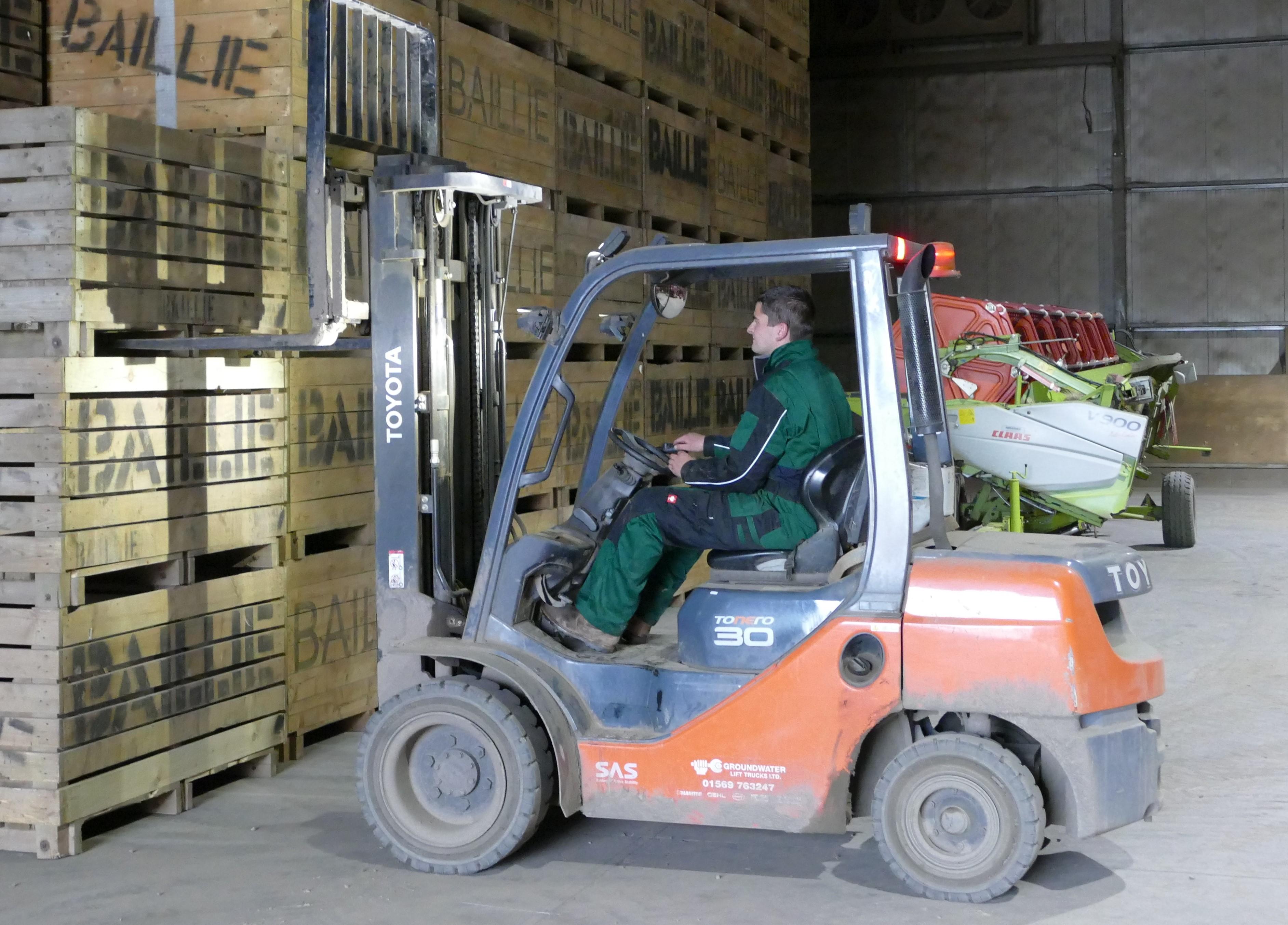 Man in boiler suit driving forklift