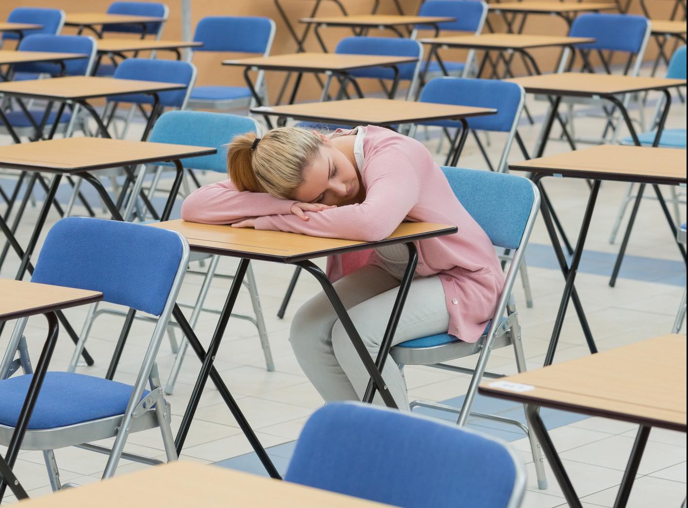 Exams: what are they good for? Girl alone at desk after exam ends