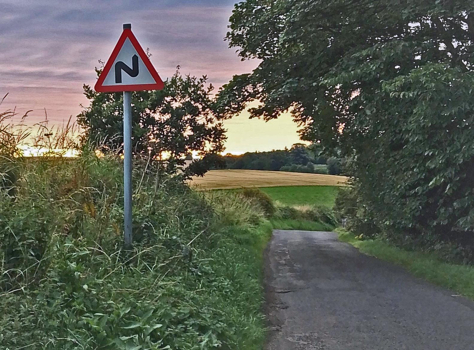 Road sign with countryside and road