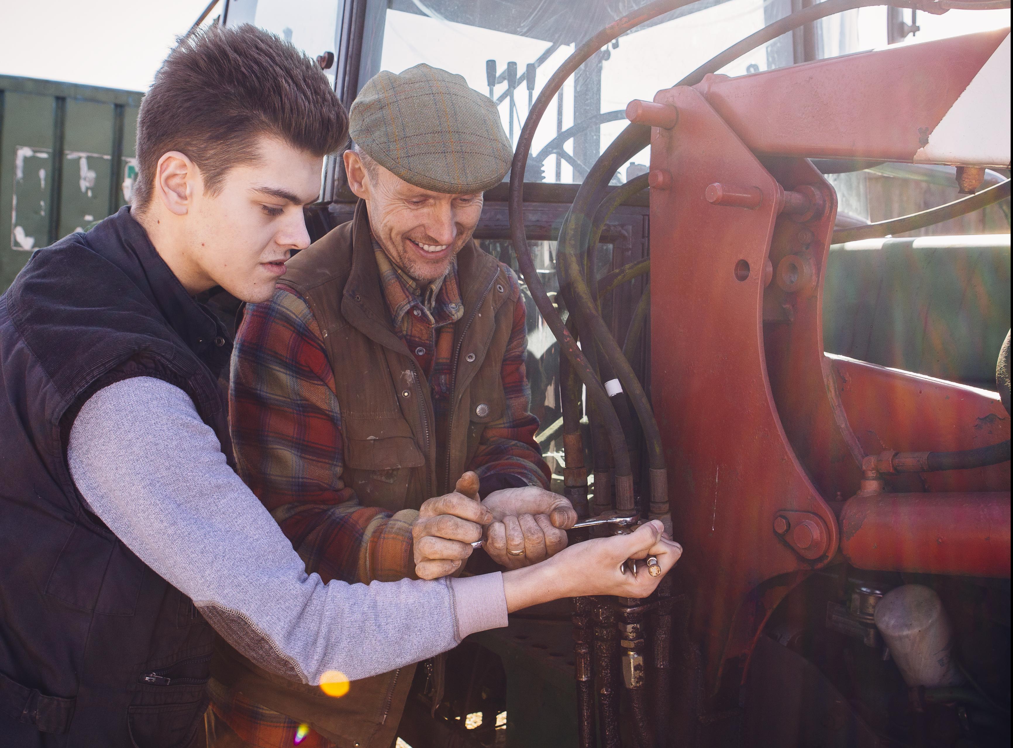 Two men working on a tractor