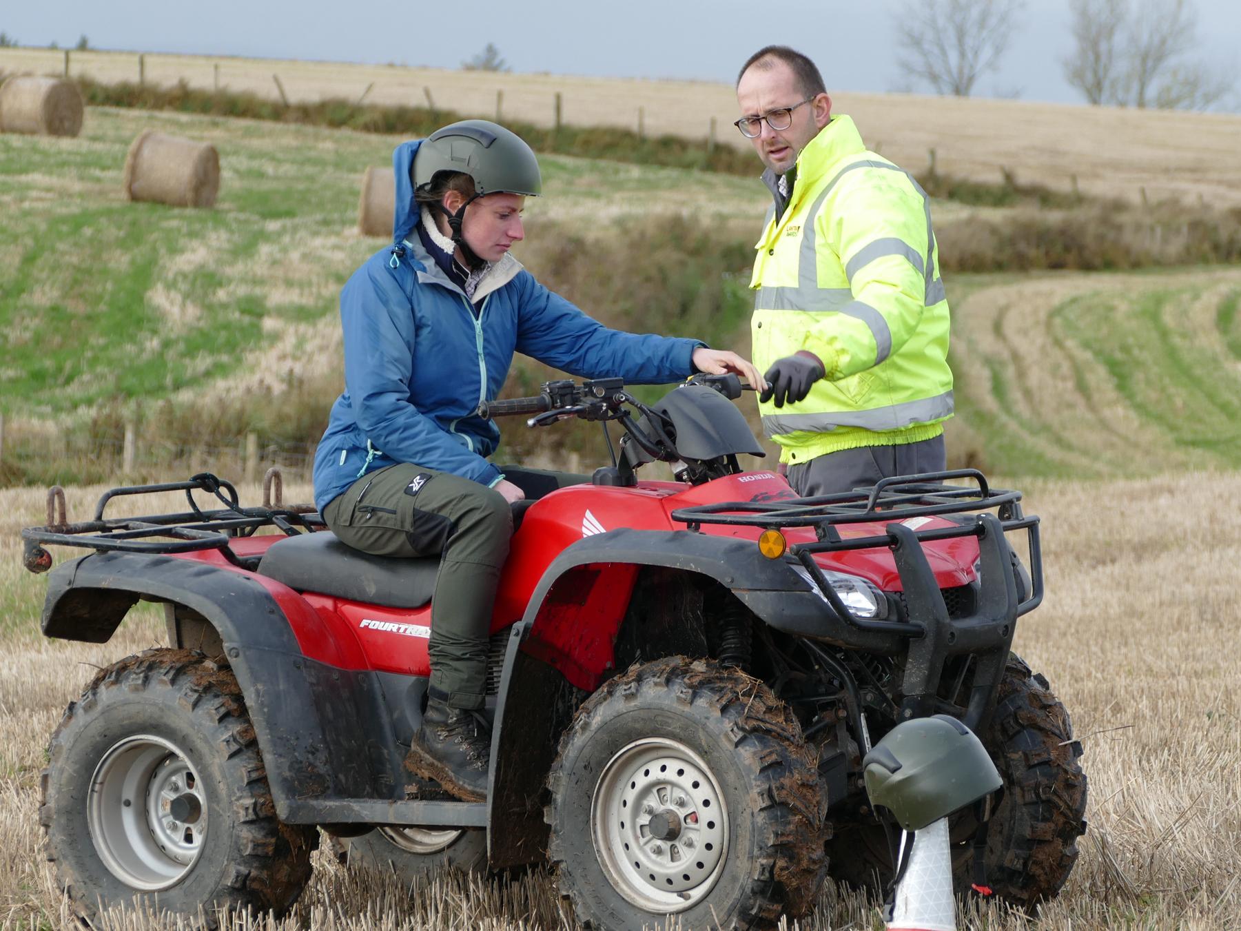 Woman using a quad bike with male instructor