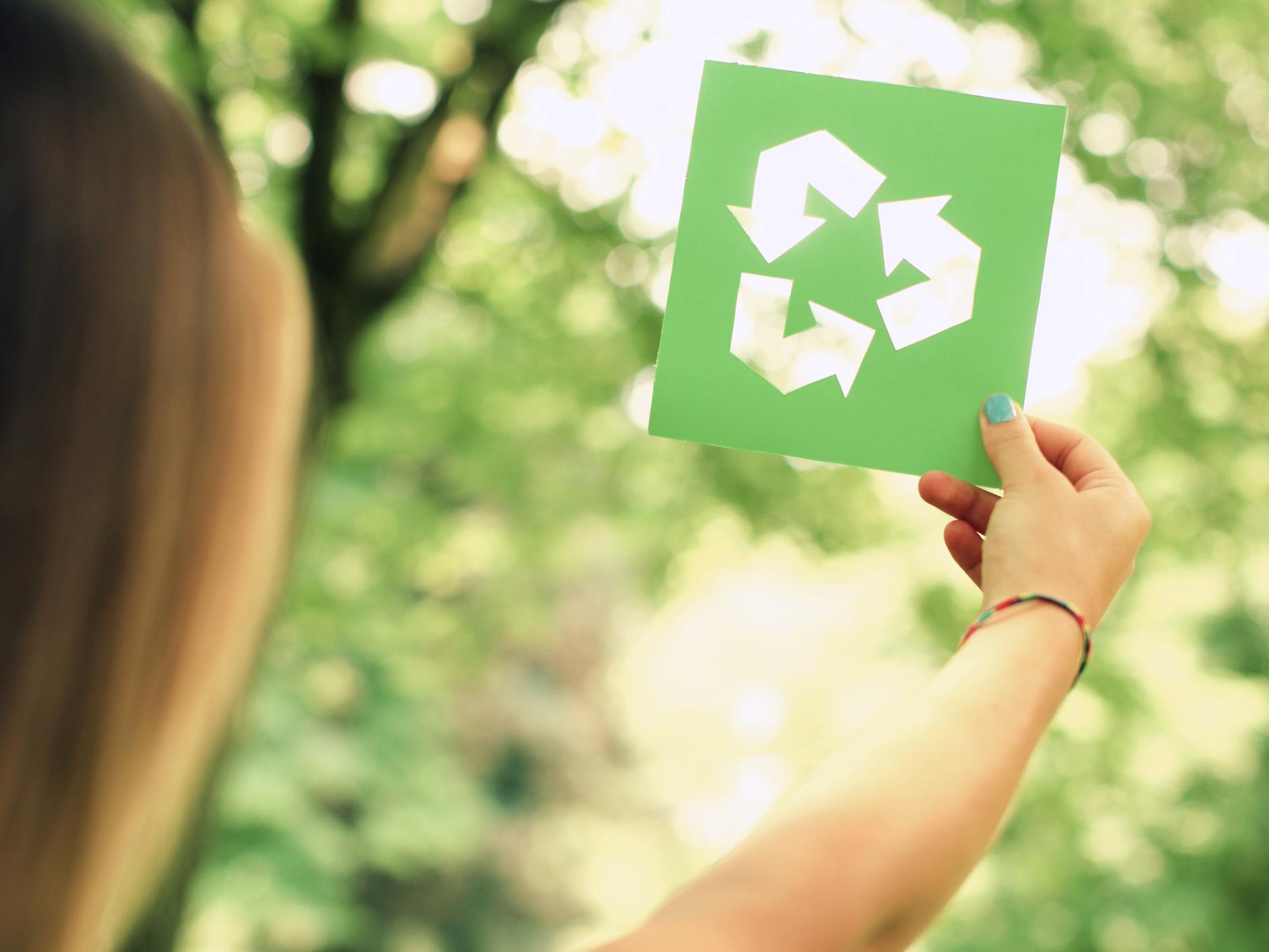 Woman holding up recycling sign