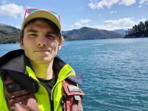 Man wearing lifejacket in front of water