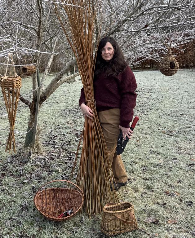 Woman holding willow branches in frosty orchard